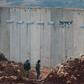 Israeli soldiers stand bye the concrete barrier erected along the border with Lebanon near the northern Israeli town of Metula: a Un investigation said two tunnels dug by Hezbollah stretched beneath the border line and into Israeli territory