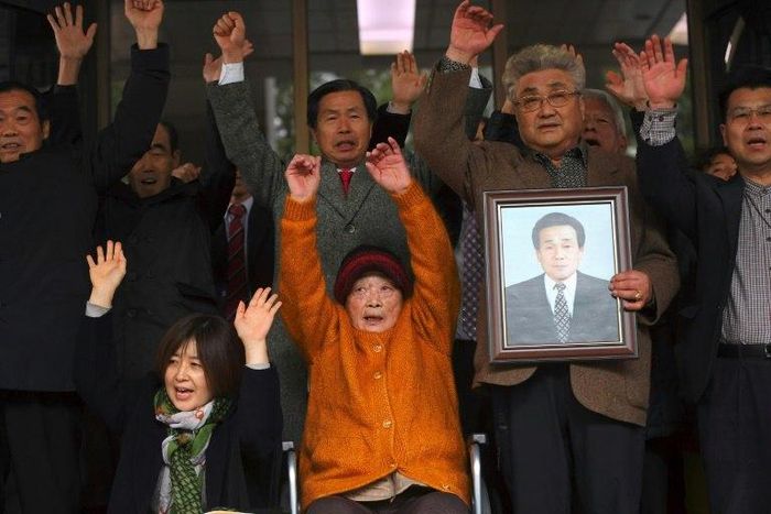 Kim Sung-joo (in orange), a victim of forced labour by Japan, cheered in reaction to the court decision