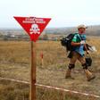 The pine-fringed village's former pasture is cordoned off and marked by signs reading "Danger, mines" in English