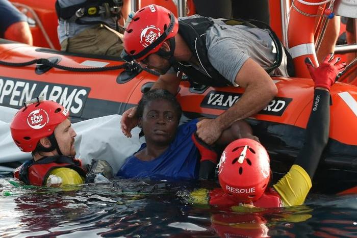 Members of the Spanish NGO Proactiva Open Arms rescue a woman in the Mediterranean sea in July 2018