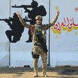 A member of Iraq's Rapid Response military unit poses in front of a mural glorifying Iraqi forces