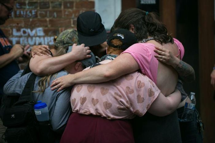 Mourners embrace next to a makeshift memorial to Heather Heyer in Charlottesville, Virginia, on the one year anniversary of her death at the hands of a white supremacist in a speeding car