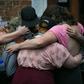 Mourners embrace next to a makeshift memorial to Heather Heyer in Charlottesville, Virginia, on the one year anniversary of her death at the hands of a white supremacist in a speeding car