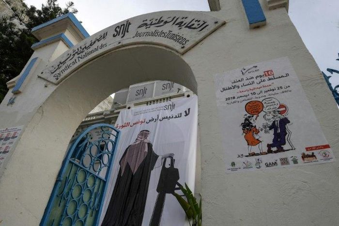 A banner at the headquarters of Tunisia's journalists union in Tunis depicting a man in traditional Saudi dress holding a chainsaw with a caption reading "no to the desecration of Tunisia, land of the revolution"
