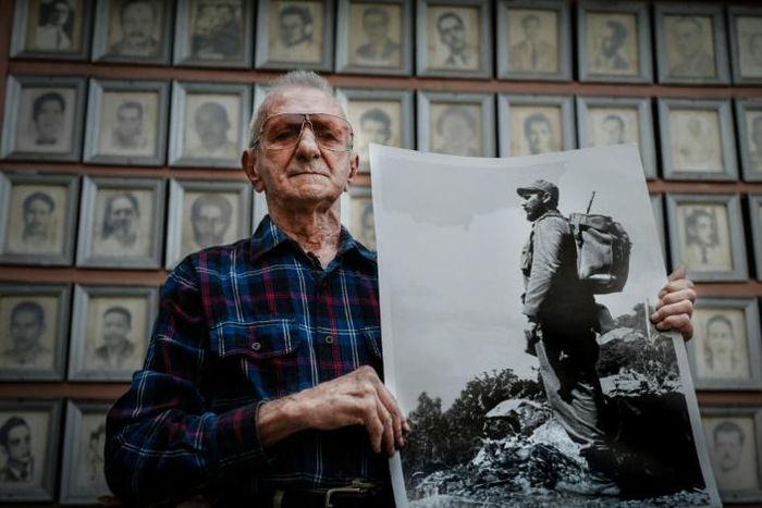 Cuban veteran Alejandro Ferras Pellicer poses with a picture of late leader Fidel Castro at his personal revolution museum in Havana