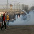 Palestinian protesters demonstrate amid tear gas fired by Israeli troops at the Erez border crossing with Israel in the northern Gaza Strip on October 3, 2018
