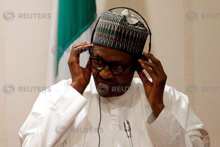 Nigeria's President Muhammadu Buhari adjusts his translation device during a news conference at the presidential villa in Abuja, Nigeria, August 31, 2018.