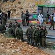 Israeli forces and forensic experts inspect the site of a gun attack at Asaf Junction in the West Bank on December 13, 2018
