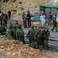 Israeli forces and forensic experts inspect the site of a gun attack at Asaf Junction in the West Bank on December 13, 2018