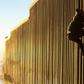 A Honduran migrant climbs the US-Mexico border fence on December 8, 2018