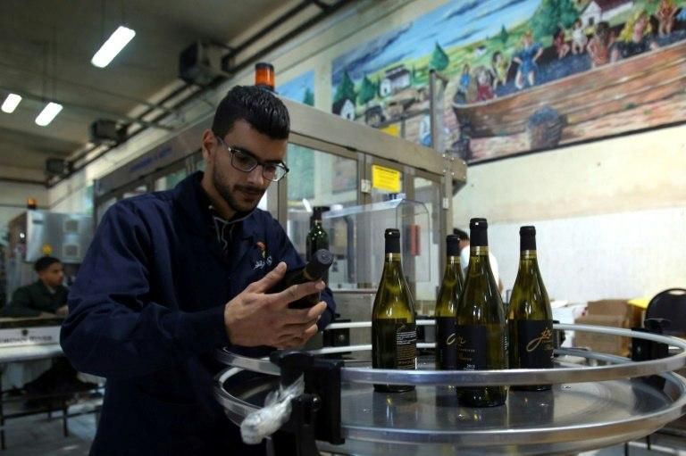 Workers inspect bottles at Eagle Distilleries in Zarqa, east of Amman -- but while the makers say the wine is "exceptional" high duties and taxes make it expensive