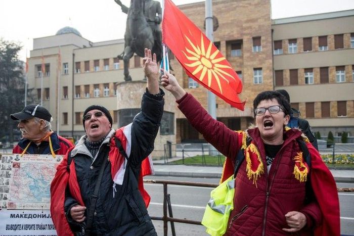 Demonstrators wave an old Macedonian flag during a protest against a process of renaming the country name in front of the Parliament building in Skopje on December 1, 2018, during the Parliament session