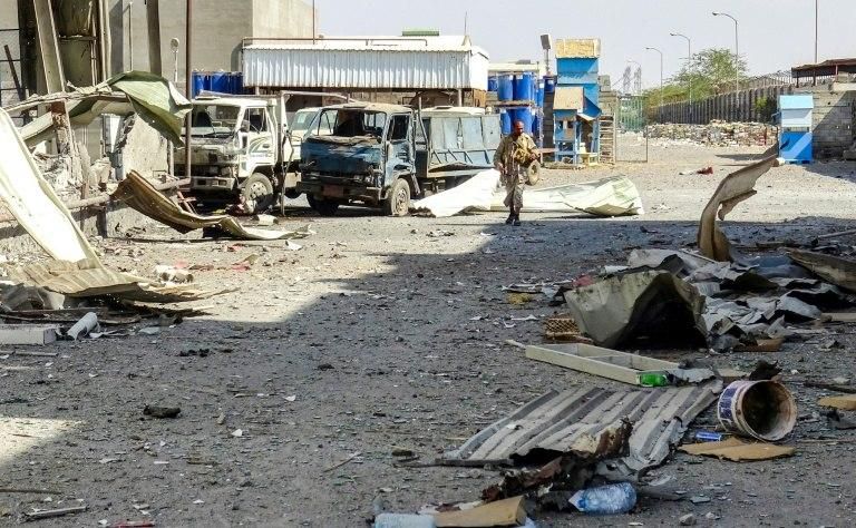 A member of Yemen's pro-government forces walks through destruction in an industrial district in the eastern outskirts of the port city of Hodeida
