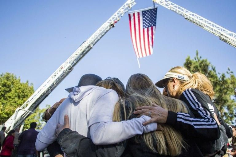 Friends hug outside Los Robles Medical Center in Thousands Oaks, California, paying tribute to a police officer killed at the Borderline Bar and Grill
