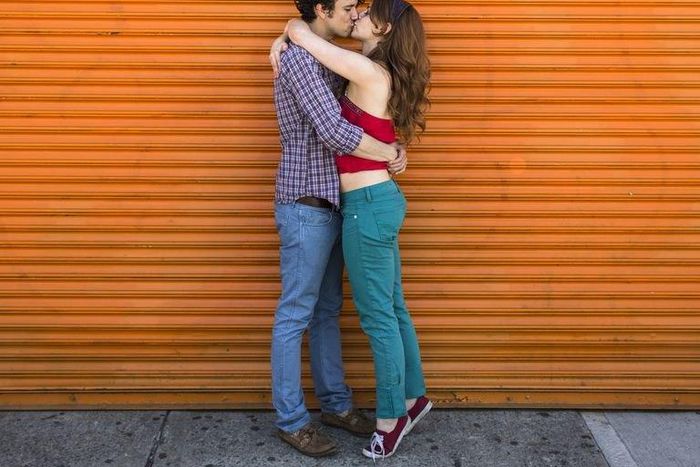 ___8918187___2018___9___29___20___romantic-couple-kissing-in-front-of-orange-shutter-royalty-free-image-501884093-1537805601