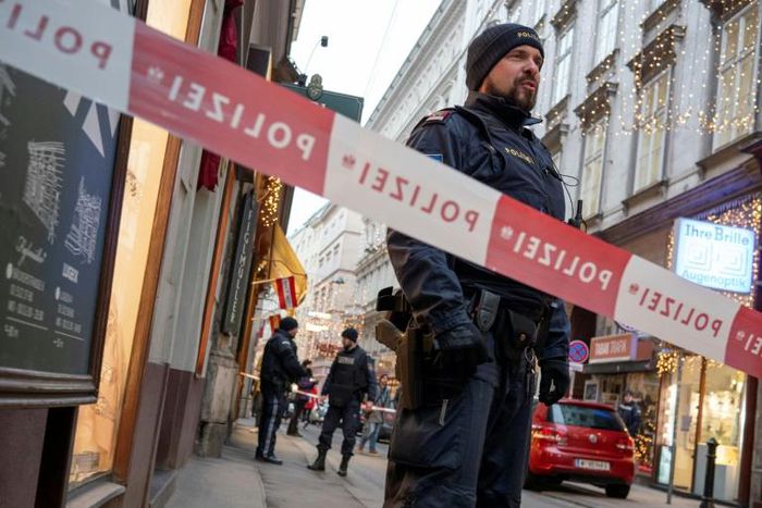 Austrian policemen stand guard at the site of a shooting outside Figlmueller passage in the city center of Vienna on December 21, 2018