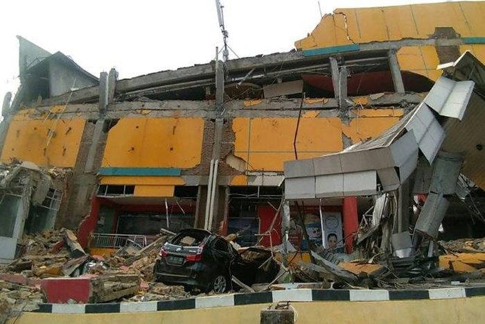 A collapsed building in Palu: an air traffic controller is being hailed as a hero after staying at his post during the quake