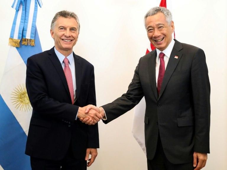 This handout picture released by the Argentinian Presidency shows Argentina's President Mauricio Macri (L) welcoming Singapore's Prime Minister Lee Hsien Loong on arrival in Buenos Aires on November 29, 2018
