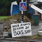 One of the 'yellow vest' protesters helps the construction work at a roundabout in Brest, western France. The sign next to him reads '"We need more wood, please'.