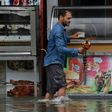 A shop owner tries to salvage his merchandise in a street flooded by torrential rains in the Tunisian capital Tunis on October 18, 2018