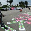 Policemen step on campaign posters of candidates who are jostling for the People's Democratic Party (PDP) presidential nomination ahead of the country's 2019 elections