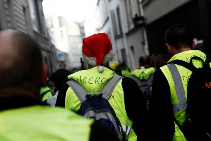 A yellow vest protestor with a Christmas hat walks in the Montmartre area in Paris, one of several demonstrations across France, albeit numbers were down on previous rallies