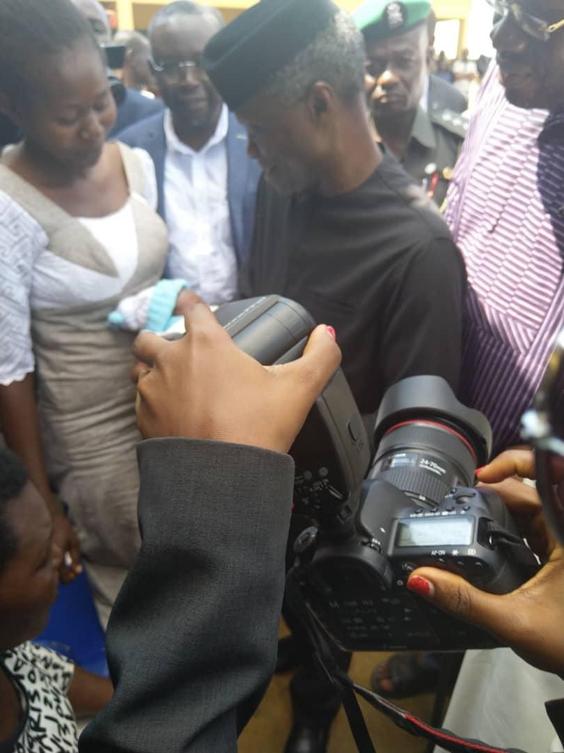 Vice President Yemi Osinbajo cradles new born given birth to in IDP camp