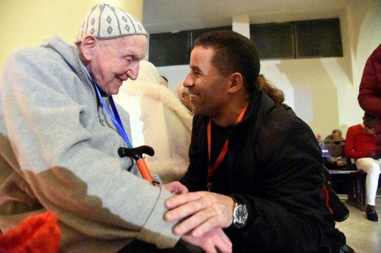 French Catholic monk Brother Jean-Pierre Schumacher (L) greets a man ahead of the beatification ceremony for 19 Catholic clergy in Agleria's northwestern city of Oran on Saturday