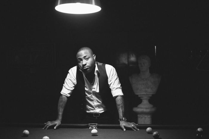 Davido leans against a pool table for his Native magazine shoot