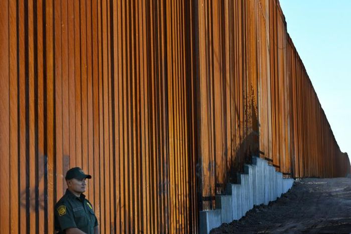 A guard stands watch at the wall along the US-Mexico border