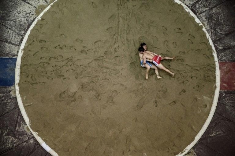 Wrestling matches in South Korea are held on sand, as pictured, while the North uses a round mattress