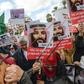 Tunisian women hold up saws and signs saying in Arabic, "No welcome, Tunisians against the visit of the Saudi Crown Prince to Tunisia", during an anti-Saudi Crown Prince protest in Tunis on November 27, 2018