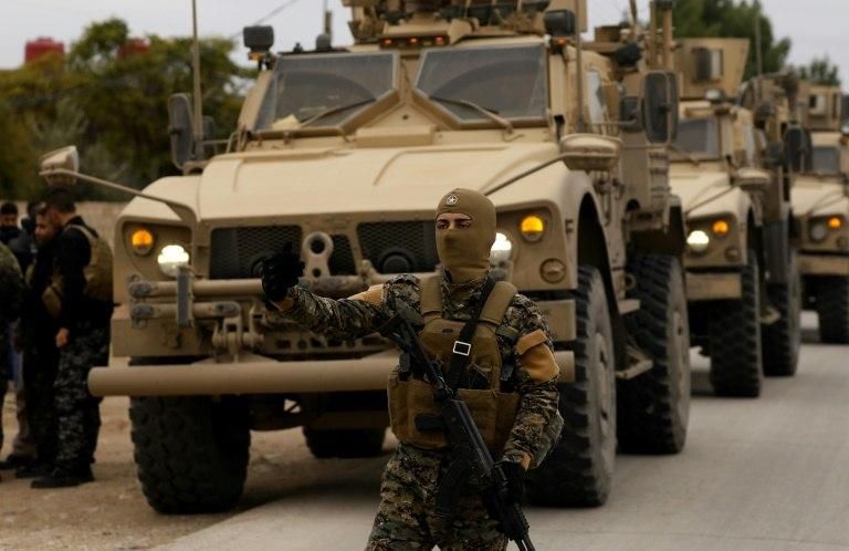 US soldiers and fighters of the Syrian Democratic Forces carry out a joint patrol of the Kurdish town of Al-Darbasiyah on the Turkish border on November 4, 2018, in a confidence-building move adopted after Turkish threats on the Kurdish heartland