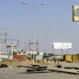 Members of the Yemeni pro-government forces walk through destruction in an industrial district in the eastern outskirts of the port city of Hodeida