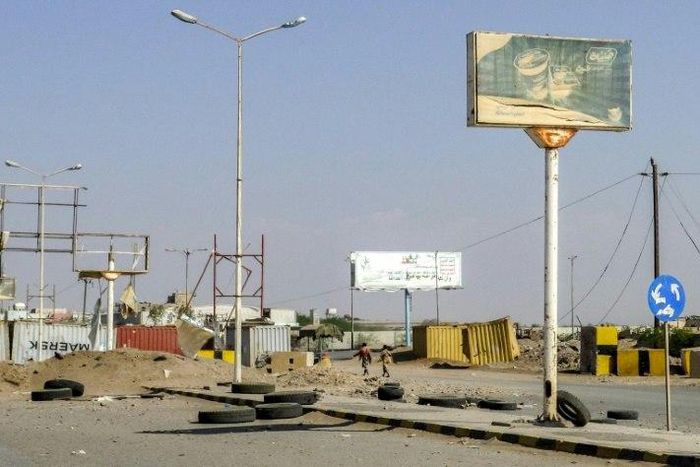 Members of the Yemeni pro-government forces walk through destruction in an industrial district in the eastern outskirts of the port city of Hodeida