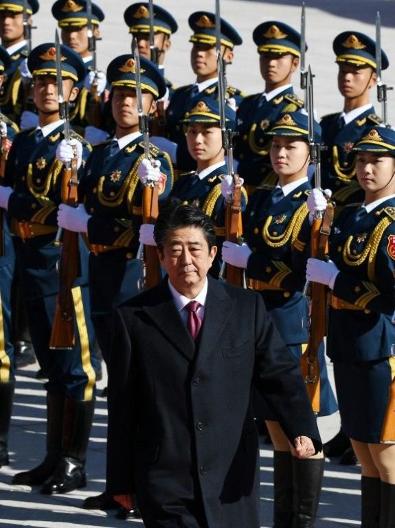 Japan's Prime Minister Shinzo Abe reviewed a military honour guard before heading into the the opulent Great Hall of the People for talks