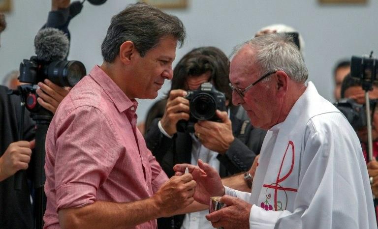 Haddad, pictured receiving communion during a mass at Our Lady of Aparecida Basilica, is trying to rally Catholics to his campaign