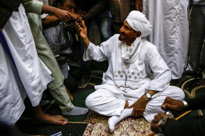 Sadiq al-Mahdi, Sudan's ex-prime minister and leader of the opposition Umma Party, is greeted by supporters in a mosque in the capital Khartoum's twin city of Omdurman on December 19, 2018 after his return from exile