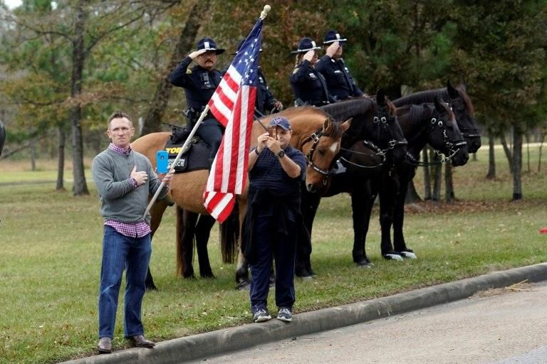 People line the road as the hearse carrying the flag-draped casket of former US president George H.W. Bush heads to a Houston train station, for a final trip to the late leader's presidential library
