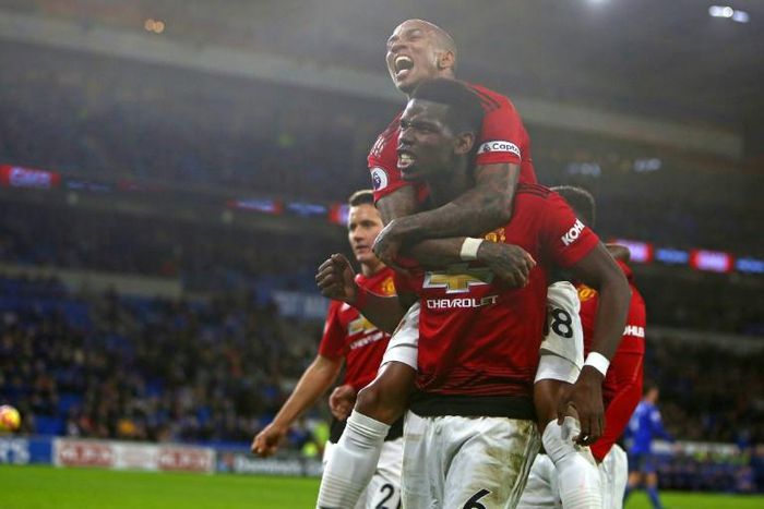 Ashley Young (top) climbs on Paul Pogba in celebration during Manchester United's 5-1 win at Cardiff