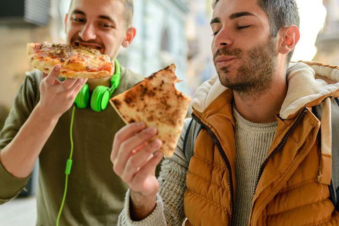 ___9083356___2018___11___8___9___male-friends-having-pizza-royalty-free-image-985191284-1541601754