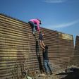 A group of Central American migrants climb the border fence between Mexico and the United States near El Chaparral border crossing in Tijuana -- the crisis is ongoing