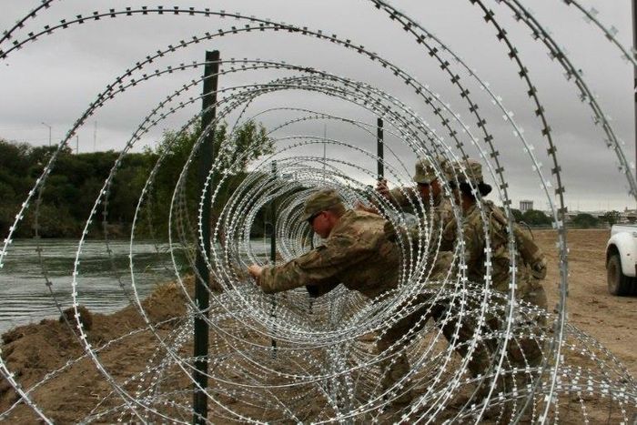 Soldiers from the Kentucky-based 19th Engineer Battalion installing barbed wire fences on the banks of the Rio Grande in Laredo, Texas