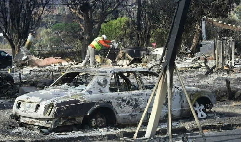 Workers check gas lines amid damaged homes from the "Woolsey Fire" in Malibu, California