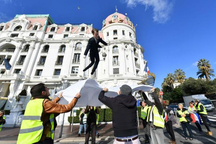 "Yellow vest" protesters use a sheet to bounce an effigy of President Emmanuel Macron in Nice, southern France, during nationwide demonstrations on Saturday, December 15