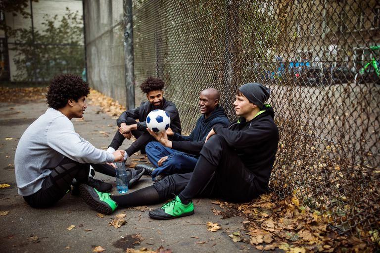 ___9175535___2018___12___6___22___soccer-players-talking-while-sitting-against-fence-royalty-free-image-901575296-1544040094
