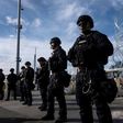US border control agents stand in formation during a show of force as Central American migrants mass on the other side of the frontier
