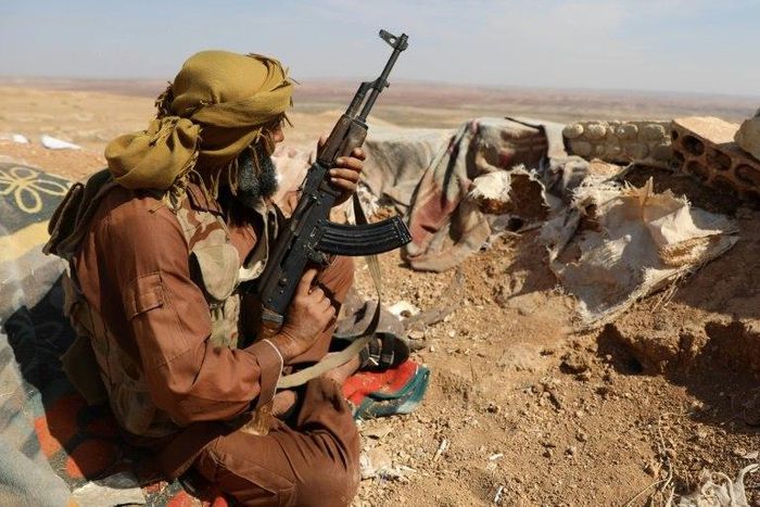 A rebel fighter takes position in a trench in the area of Al-Eis in northern Syria on October 7