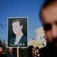 Syrian Kurds hold a portrait of President Bashar al-Assad during a demonstration in the northeastern city of Qamishli on December 23, 2018, seeking protection by the Syrian army against Turkey following a shock US decision to withdraw its troops