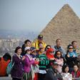 Tourists pose for a group picture at the Giza pyramids on the southwestern outskirts of the Egyptian capital Cairo on December 29, 2018